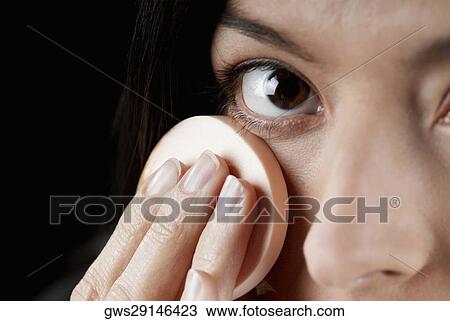 Portrait of a woman applying face powder with a powder puff View Large Photo Image Stock Image - Portrait of a woman applying face powder with a powder puff. Fotosearch