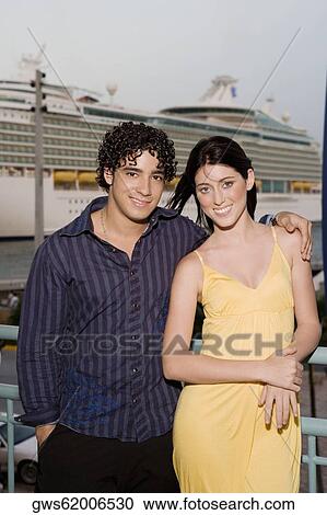 Stock Image - Portrait of a young man and a teenage girl standing together and smiling. Fotosearch