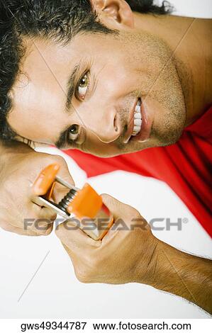 Portrait of a young man holding a clamp View Large Photo Image Stock Photo - Portrait of a young man holding a clamp. Fotosearch