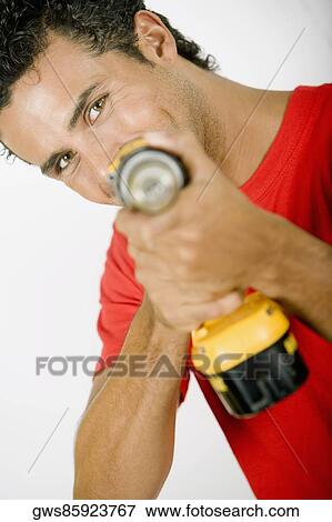 Portrait of a young man holding a drill machine View Large Photo Image Stock Photo - Portrait of a young man holding a drill machine. Fotosearch
