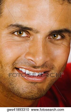 Stock Image - Portrait of a young man holding a paint can and smiling. Fotosearch