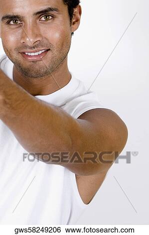 Stock Photograph - Portrait of a young man holding a paint roller and smiling. Fotosearch