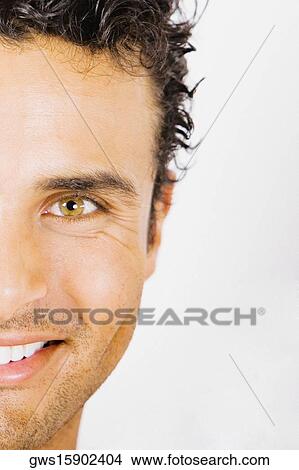 Portrait of a young man holding a paintbrush in front of his face and smiling View Large Photo Image Picture - Portrait of a young man holding a paintbrush in front of his face and smiling. Fotosearch