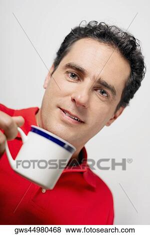 Portrait of a young man holding a tea cup View Large Photo Image Stock Photo - Portrait of a young man holding a tea cup. Fotosearch