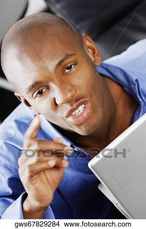 Portrait of a young man in front of a laptop View Large Photo Image Picture - Portrait of a young man in front of a laptop. Fotosearch