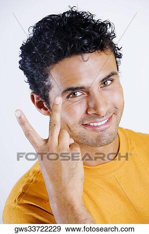Portrait of a young man making a peace sign View Large Photo Image Stock Photo - Portrait of a young man making a peace sign. Fotosearch