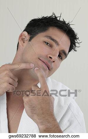 Portrait of a young man pointing to his chin View Large Photo Image Stock Photo - Portrait of a young man pointing to his chin. Fotosearch