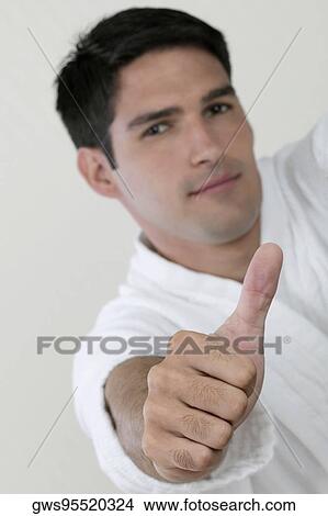 Picture - Portrait of a young man showing a thumbs up sign. Fotosearch