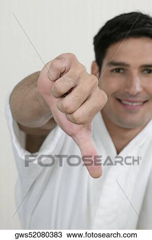 Portrait of a young man showing a thumbs down sign View Large Photo Image Stock Image - Portrait of a young man showing a thumbs down sign. Fotosearch