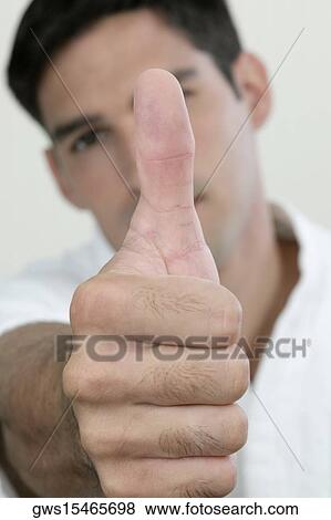 Stock Photo - Portrait of a young man showing a thumbs up sign. Fotosearch