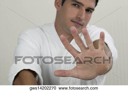 Portrait of a young man showing a stop gesture View Large Photo Image Stock Image - Portrait of a young man showing a stop gesture. Fotosearch