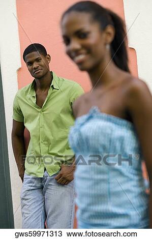 Stock Image - Portrait of a young man standing behind a teenage girl. Fotosearch