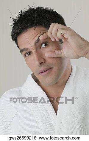 Portrait of a young man stretching his eye with his fingers View Large Photo Image Stock Photo - Portrait of a young man stretching his eye with his fingers. Fotosearch
