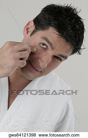Portrait of a young man stretching his eyes with his fingers View Large Photo Image Stock Photo - Portrait of a young man stretching his eyes with his fingers. Fotosearch