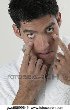 Portrait of a young man stretching his eyes with his fingers View Large Photo Image Stock Photography - Portrait of a young man stretching his eyes with his fingers. Fotosearch