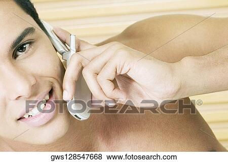 Portrait of a young man talking on a mobile phone View Large Photo Image Stock Photo - Portrait of a young man talking on a mobile phone. Fotosearch