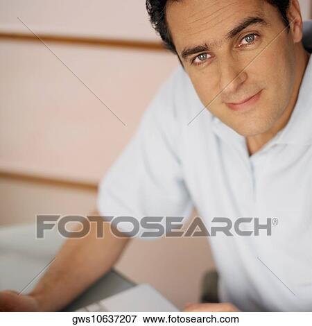Portrait of a young man using a laptop View Large Photo Image Stock Photo - Portrait of a young man using a laptop. Fotosearch