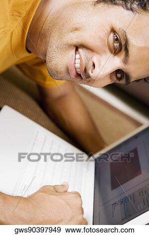 Stock Photo - Portrait of a young man using a laptop. Fotosearch