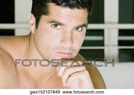 Portrait of a young man with his hand on his chin View Large Photo Image Stock Photo - Portrait of a young man with his hand on his chin. Fotosearch