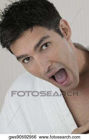 Stock Photograph - Portrait of a young man with his mouth open. Fotosearch