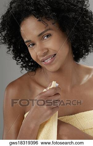Stock Photograph - Portrait of a young woman adjusting a towel. Fotosearch