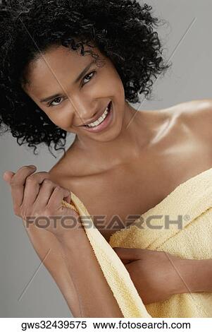 Portrait of a young woman adjusting a towel and smiling View Large Photo Image Stock Photography - Portrait of a young woman adjusting a towel and smiling. Fotosearch