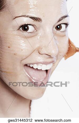 Portrait of a young woman applying a facial mask View Large Photo Image Stock Image - Portrait of a young woman applying a facial mask. Fotosearch