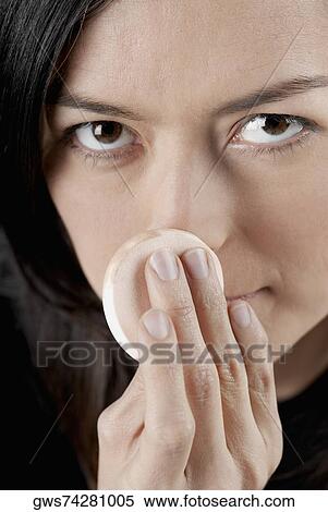 Portrait of a young woman applying face powder View Large Photo Image Stock Photography - Portrait of a young woman applying face powder. Fotosearch