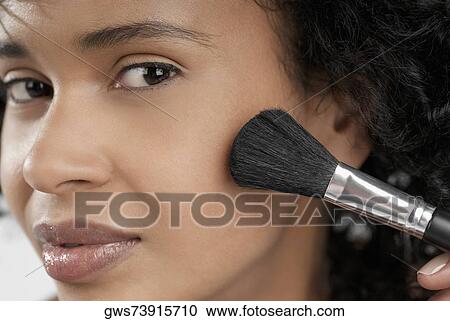 Portrait of a young woman applying blush with a brush View Large Photo Image Stock Image - Portrait of a young woman applying blush with a brush. Fotosearch
