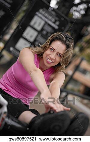 Stock Image - Portrait of a young woman doing sit-ups and touching her toes. Fotosearch