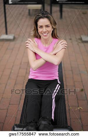Stock Photo - Portrait of a young woman doing sit-ups on a weight bench. Fotosearch