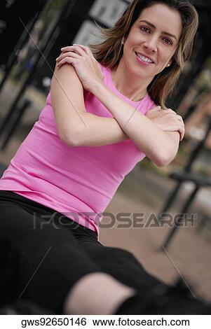 Stock Photograph - Portrait of a young woman doing sit-ups with her arms crossed. Fotosearch