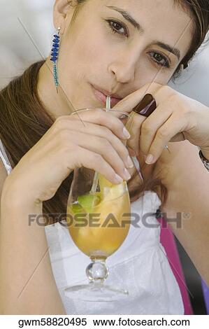 Portrait of a young woman drinking a glass of juice View Large Photo Image Stock Photography - Portrait of a young woman drinking a glass of juice. Fotosearch