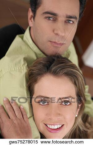 Stock Photography - Portrait of a young woman embracing a young man. Fotosearch