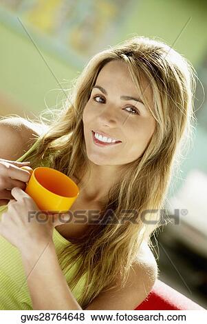 Portrait of a young woman holding a cup View Large Photo Image Stock Photo - Portrait of a young woman holding a cup. Fotosearch