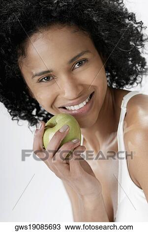 Portrait of a young woman holding an apple View Large Photo Image Stock Image - Portrait of a young woman holding an apple. Fotosearch