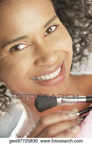 Portrait of a young woman holding make-up brushes in a purse View Large Photo Image Stock Image - Portrait of a young woman holding make-up brushes in a purse. Fotosearch
