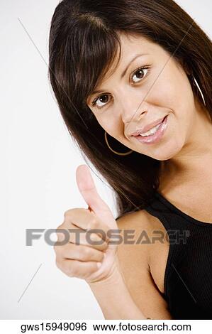 Portrait of a young woman making Thumbs Up sign and smiling View Large Photo Image Stock Photograph - Portrait of a young woman making Thumbs Up sign and smiling. Fotosearch