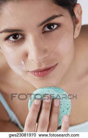 Portrait of a young woman scrubbing her chin with a sponge View Large Photo Image Stock Image - Portrait of a young woman scrubbing her chin with a sponge. Fotosearch