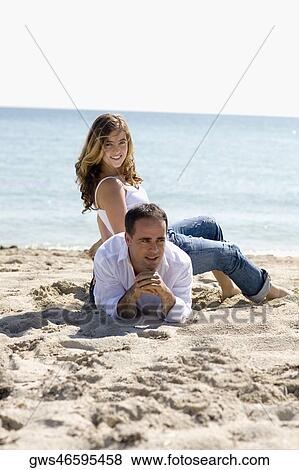 Stock Photo - Portrait of a young woman sitting on the back of a mid adult man. Fotosearch
