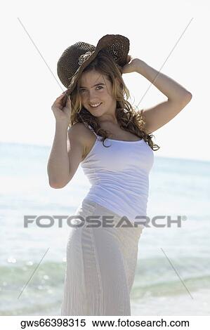 Portrait of a young woman standing on the beach and smiling View Large Photo Image Stock Photography - Portrait of a young woman standing on the beach and smiling. Fotosearch