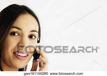Portrait of a young woman using a mobile phone and smiling View Large Photo Image Stock Image - Portrait of a young woman using a mobile phone and smiling. Fotosearch