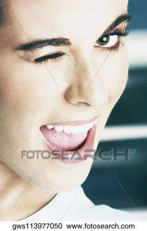 Portrait of a young woman winking View Large Photo Image Stock Image - Portrait of a young woman winking. Fotosearch