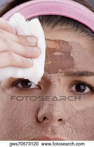 Portrait of a young woman wiping off her face facial mask with cotton View Large Photo Image Stock Image - Portrait of a young woman wiping off her face facial mask with cotton. Fotosearch