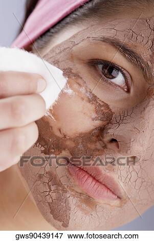 Portrait of a young woman wiping off her face facial mask with cotton View Large Photo Image Stock Photo - Portrait of a young woman wiping off her face facial mask with cotton. Fotosearch