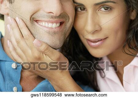 Portrait of a young woman with her hand on a young man's chin View Large Photo Image Stock Photo - Portrait of a young woman with her hand on a young man's chin. Fotosearch