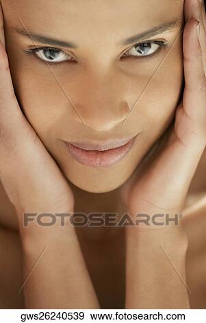Portrait of a young woman with her hands on her head View Large Photo Image Stock Photo - Portrait of a young woman with her hands on her head. Fotosearch