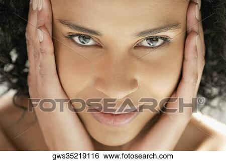 Portrait of a young woman with her hands on her head View Large Photo Image Stock Photograph - Portrait of a young woman with her hands on her head. Fotosearch