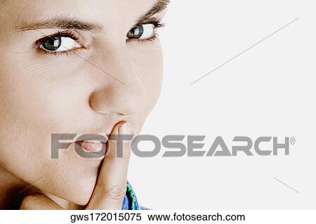 Portrait of a young woman with her finger on her lips View Large Photo Image Stock Photography - Portrait of a young woman with her finger on her lips. Fotosearch