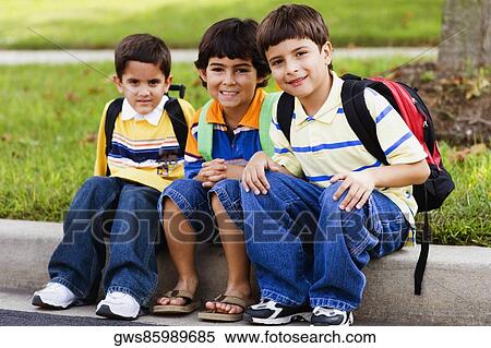 Portrait of three schoolboys sitting together and smiling View Large Photo Image Stock Photography - Portrait of three schoolboys sitting together and smiling. Fotosearch